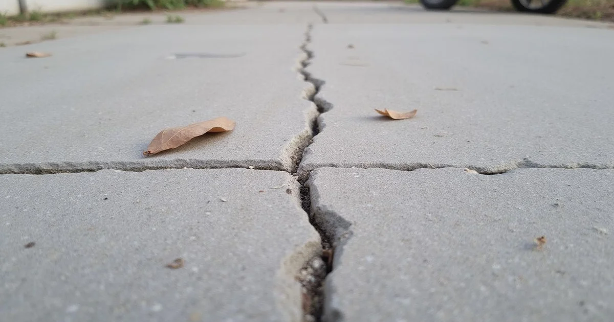 A sealed hairline crack in a concrete surface with the filler visible along the line