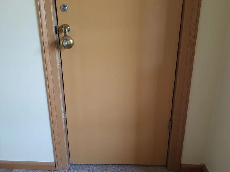 Interior door that no longer closes squarely, showing an uneven gap along the top of the frame